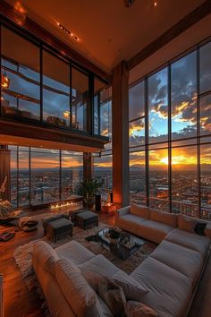 a living room filled with lots of furniture and large windows overlooking the city at sunset