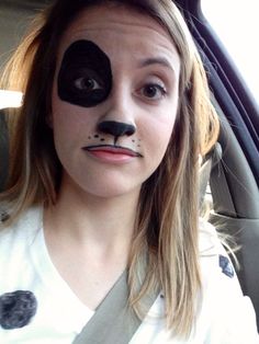 a woman with her face painted to look like a cat in the hat, sitting in a car