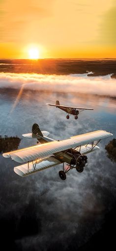 two airplanes flying in the sky above clouds