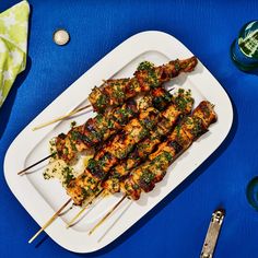 several skewers of food on a white plate