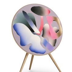 an abstract painting is displayed on a wooden tripod stand with two legs and a white background