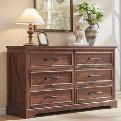 a wooden dresser sitting next to a mirror and lamp