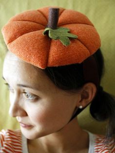 a woman wearing an orange hat with a leaf on it