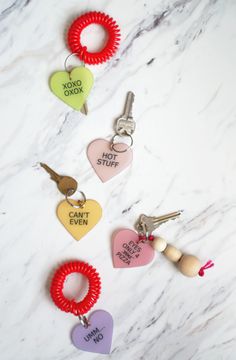 keychains with different types of heart shaped tags attached to them on a marble surface