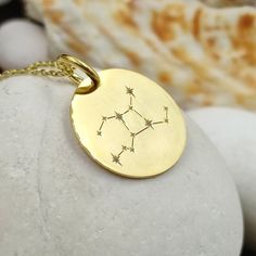 a gold plated necklace with stars on it sitting on top of a white rock