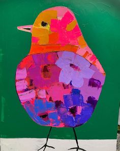 a painting of a colorful bird on a green background