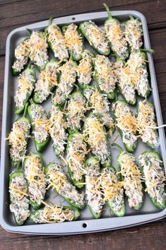 green peppers stuffed with cheese and other toppings on a baking sheet ready to go into the oven