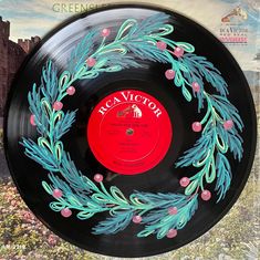 a record with an image of a wreath painted on the front and side of it