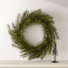 Accented with soft white LED lights, faux pine holiday wreath recreates the delicate needles of evergreen boughs for a burst of lively color and texture that lasts season after season. Hang on the wall or above the mantel with a single loop for a beautiful botanical display. Pair with the faux needle pine Christmas tree. CB2 exclusive.     Iron frame with blend of PPE/PVC branch tips  Pre-strung with white LED bulbs  Loop for hanging  For indoor and sheltered outdoor use  Imported  Imported Need Holiday Mantel Decor, Botanical Display, Modern Christmas Ornaments, Feather Wreath, Unique Holiday Decor, White Christmas Ornaments, Holiday Mantel, Pine Christmas Tree, Tree Collar