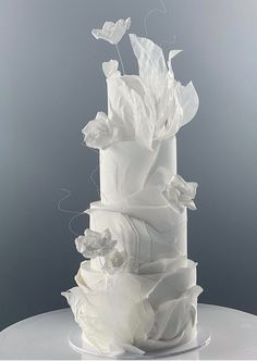 a white wedding cake with flowers and butterflies on top