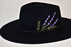 Each of these hats is hand embroidered with beautifully detailed lavender sprigs. They are embroidered to order and ready to ship in 1-2 weeks! Please reach out with any questions or requests for timing. The hat is 100% Australian wool in a western weight, so it has a stiff and sturdy feel. The crown is 4" tall and the brim is 3.5" wide. There are two size options, 58cm and 60cm, and they are adjustable inside to tighten (4cm down each). For more information on sizing, visit my FAQ page. Embroidered Felt Hat, Painted Hats For Women, Hat Embroidery Ideas, Lavender Sprigs, Lavender Haze, Feather Hat, Hat Embroidery, Embroidered Hat, Fancy Hats