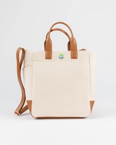 The Cape Code Tote is a truly elevated and refined take on the classic design. The design featured dual handles and a detachable strap for convenience. The spacious interior will fit all your daily needs and even works as a weekender or picnic bag. The streamlined style complements any outfit and works for his, hers, and theirs. • Natural/Saddle • 100% cotton with leather trim • Unlined • Two exterior side pockets • Leather bottom • Detachable & adjustable strap • 6” handle drop • Measures 11.5” Versatile Canvas Shopping Bag With Handles, Travel Tote Bag With Detachable Handle, Beige Weekender Bag For On-the-go, Modern Travel Bag With Detachable Double Handle, Beige Travel Bag With Handles For Everyday Use, Travel Shoulder Bag With Detachable Double Handle, Beige Travel Bag For Everyday Use, Modern Travel Bag With Detachable Top Handle, Luxury Canvas Bag With Top Carry Handle For On-the-go