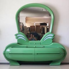 a large green mirror sitting on top of a dresser