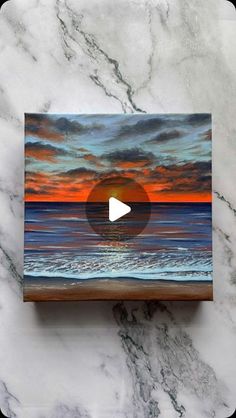 an image of the ocean at sunset with a video playing on it's screen