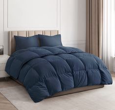 a blue comforter on a bed in a room