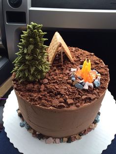 a chocolate cake decorated with rocks and trees