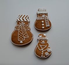 three gingerbread cookies with frosting and decorations