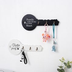 there is a key holder with two keys attached to it and a family sign hanging on the wall