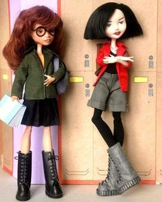 two dolls are standing next to each other