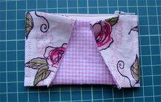 a pink and white flowered fabric has been folded to make a zipperped pouch