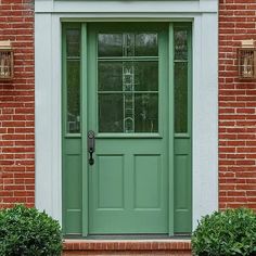 a green front door on a brick building