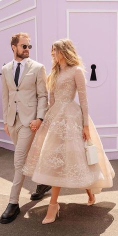 a man and woman in formal wear walking together