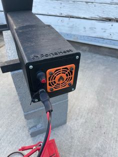 an orange and black device sitting on top of a bench