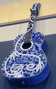 a blue and white guitar sitting on top of a table