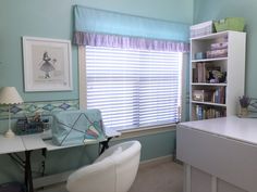 a room with a desk, chair and bookcases in front of a window