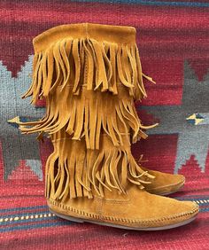 "BlackbirdSedona presents to you these Ladies Minnetonka vintage moccasin boots. They are a brown soft suede. They are 12\" High and are accented with 3 layers of fringe. These comfy shoes have rubber soles. They are in distressed and broken-in vintage condition, with signs of wear such as scuffing, soiling, and wear to soles and heels. Marked a ladies size 8. Condition notes: -Soiling inner shafts -Heavy curling of the Fringe -Heavy wear to soles Please ask questions through Etsy messages. Sinc Vintage Round Toe Moccasins For Fall, Brown Fringe Boots For Festival, Brown Bohemian Moccasins For Fall, Bohemian Brown Moccasins For Fall, Western Brown Moccasins For Festival, Western Style Brown Moccasins For Festival, Southwestern Style Brown Festival Boots, Brown Southwestern Style Festival Boots, Moccasins Boots