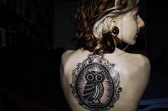 a woman with an owl tattoo on her back