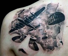 the back of a man's shoulder with an airplane and map tattoo on it