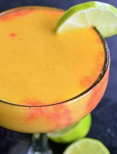 a close up of a drink with a lime on the rim