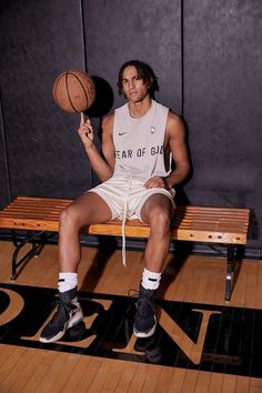 a man sitting on a bench holding a basketball