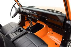 the interior of an orange and black car