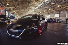 a black car parked in a garage next to other cars