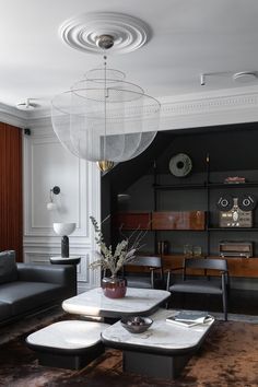 a living room filled with furniture and a chandelier hanging over the top of it