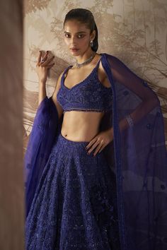 Indigo blue lehenga with bead and crystal embellished floral motifs. Comes with embellished blouse and dupatta.
Components: 3
Pattern: Embroidered
Type Of Work: Sequin,Crystal
Neckline: V-neck
Sleeve Type: Sleeveless
Fabric: Blouse and Lehenga: Net, Dupatta: Organza 
Color: Blue
Other Details: 
Bead tasselled blouse
Closure: 
Lehenga: Side Drawstring
Blouse: Side zip
Occasion: Bride,Wedding - Aza Fashions Tassel Blouse, Choli Dress, Blue Lehenga, Sequin Blouse, Bridal Lehengas, Embellished Blouse, Net Dupatta, Long Skirts, Beaded Tassels