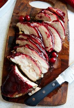 sliced up meat with cranberry sauce on a cutting board