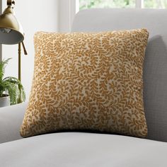 an orange and white pillow sitting on top of a couch