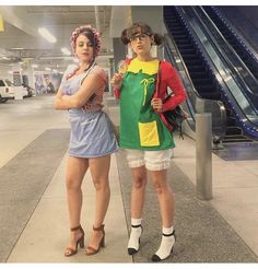 two women standing next to each other in front of an escalator