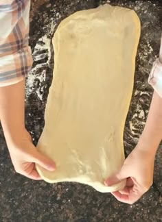 a person holding a piece of dough in their hands