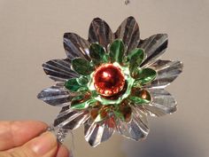 a hand holding a glass flower brooch in it's center