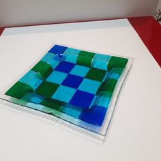 a blue and green glass plate sitting on top of a table