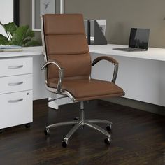 a brown office chair sitting on top of a hard wood floor next to a white desk