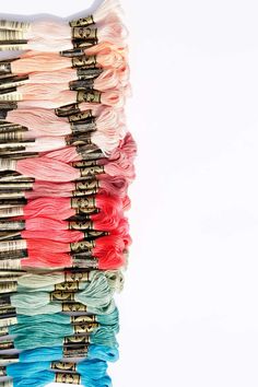 several spools of thread are stacked on top of each other in different colors