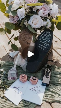 a vase filled with flowers sitting on top of a wooden table next to writing paper