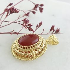 This beautiful pendant showcases a genuine 13x18mm carnelian gemstone set in an intricate gold filigree design with a diamond-cut mirror finish. Handcrafted with attention to detail, it adds elegance and sophistication to any necklace. Perfect for making a statement or as a unique gift. ✓Length : 1 3/4 inch Width : 1 1/16 inch Elegant Gold Carnelian Jewelry, Ornate Gold Oval Cabochon Jewelry, Spiritual Oval Filigree Jewelry, Elegant Carnelian Round Pendant Jewelry, Elegant Carnelian Jewelry With Large Pendant, Oval Engraved Carnelian Jewelry, Elegant Carnelian Oval Pendant Jewelry, Oval Carnelian Yellow Gold Jewelry, Traditional Gold Jewelry With Oval Cabochon