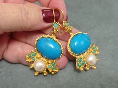 Gold plated brass earring  with blue howlite and pearl .  chandelier earrings .Turkish jewelry Antique reproduction of ottoman style handmade turkish classic earrings  Its light weight 2,5cm width 5,5 cm length dangle Styles It is hipoallergenic. It does not contain cadmium, nickel or cadmium. It is packed in a smart gift black bag with a fancy golden color envelope and an organza black bag to keep in your jewelry box or carry them. An extra pair of nuts is given as a beybiju gift. Please write Elegant Handmade Turquoise Chandelier Earrings, Handmade Turquoise Chandelier Earrings, Style Ottoman, Gemstone Earrings Dangle, Pearl Chandelier, Blue Howlite, Smart Gift, Earrings Chandelier, Turkish Jewelry