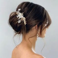 a woman wearing a wedding hair comb with flowers on it's head and pearls in her hair